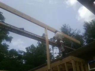 Carpenter setting a ridge beam over a new addition frame — Ice Dam Removal by Roofing Brothers in North Creek