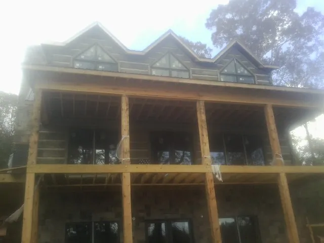 Dormers and porch framing on a large log home under construction — Roof Coating work by our crew in North Creek